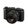 Fujifilm X-M5 mit XC 35mm F2 Objektiv in Schwarz auf weißem Hintergrund.